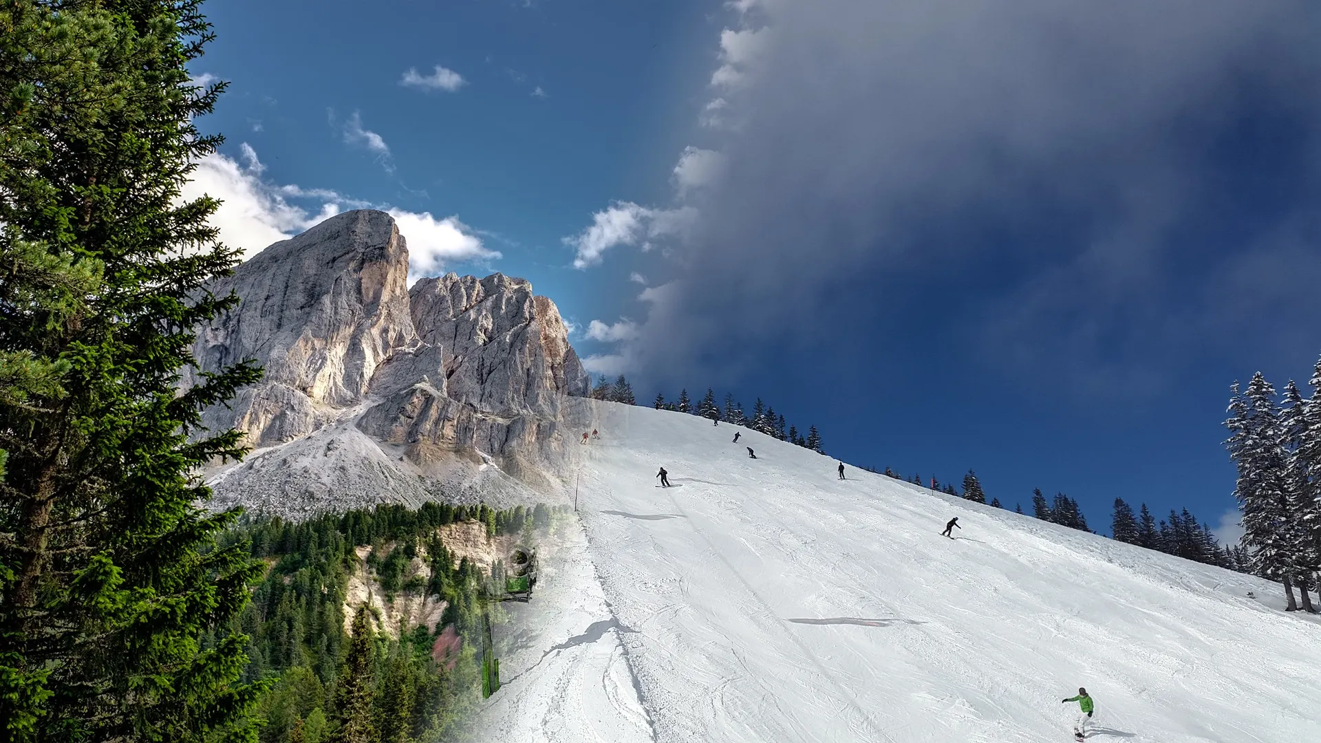 Skifahrer auf einer Piste vor einer Felswand